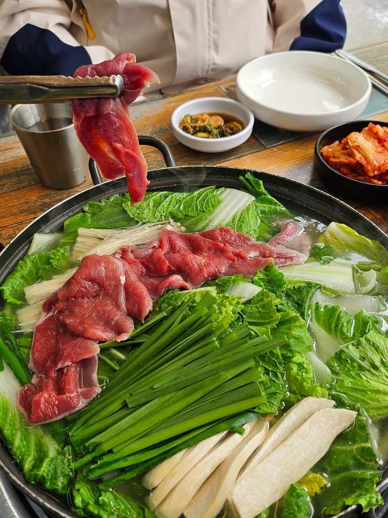 오리 샤브샤브 메뉴판과 신선한 채소가 함께 제공되는 모습